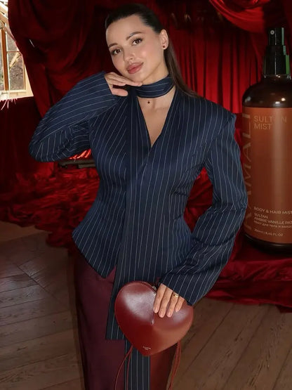 Elegant striped suit coat for women featuring a tailored fit and stylish design, paired with a heart-shaped handbag.