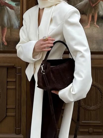 Stylish woman wearing an elegant striped suit coat for women, paired with a chic handbag