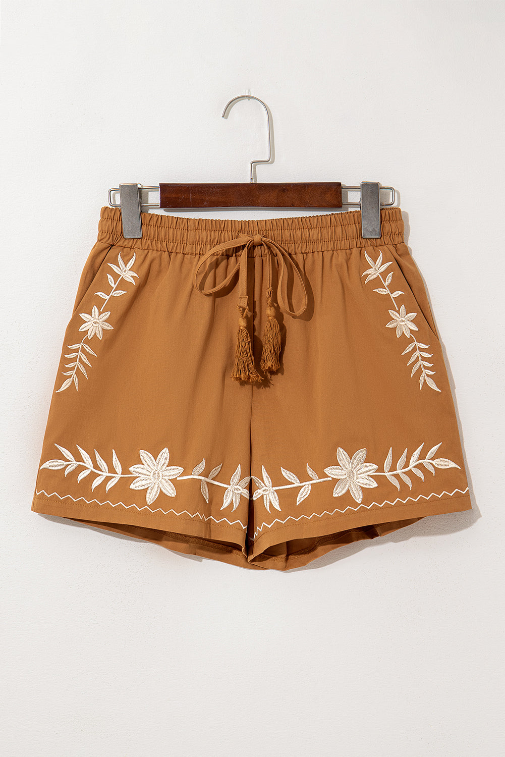LuckeLAdybug LLC embroidered shorts with floral designs and tassel drawstring in a warm brown color