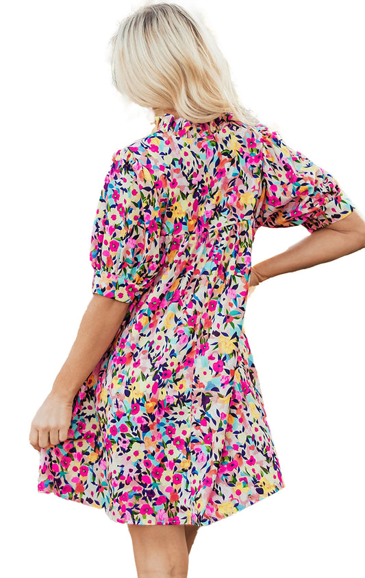 LuckeLadybug pink floral mini dress back view on model short puff sleeves tiered skirt garden setting