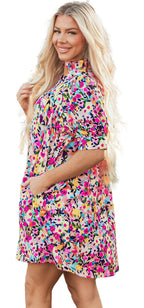 LuckeLadybug pink floral mini dress on smiling blonde model in garden loose fit with pockets and short sleeves