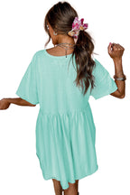 Rear view of model wearing LuckeLadybug sky blue babydoll dress with short sleeves gathered waist casual mini dress