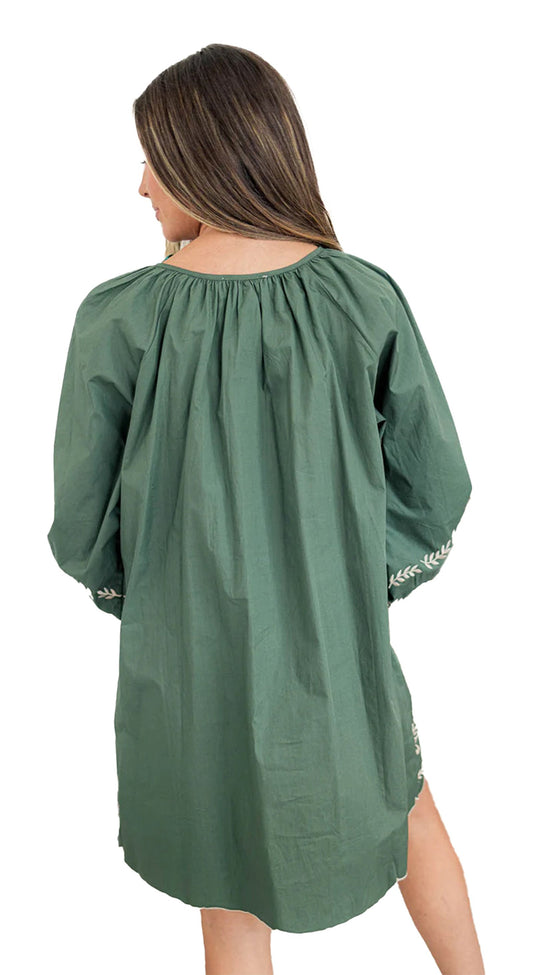 Back view of model wearing mist green boho floral dress loose mini length long sleeves embroidered cuffs
