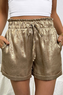 Pantalones cortos con brillo metálico dorado, cintura elástica y dobladillo vuelto