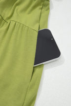Green Fit & Flare style and maxi dress with a pocket holding a smartphone for convenience