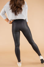 Black leggings made from faux leather material, perfect for stylish and comfortable everyday wear