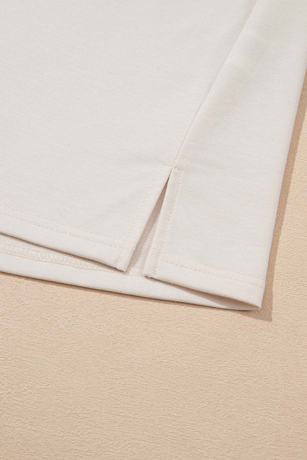 Close-up of beige T-Shirt hem detail from LuckeLadybug LLC with a stylish floral dress dress design