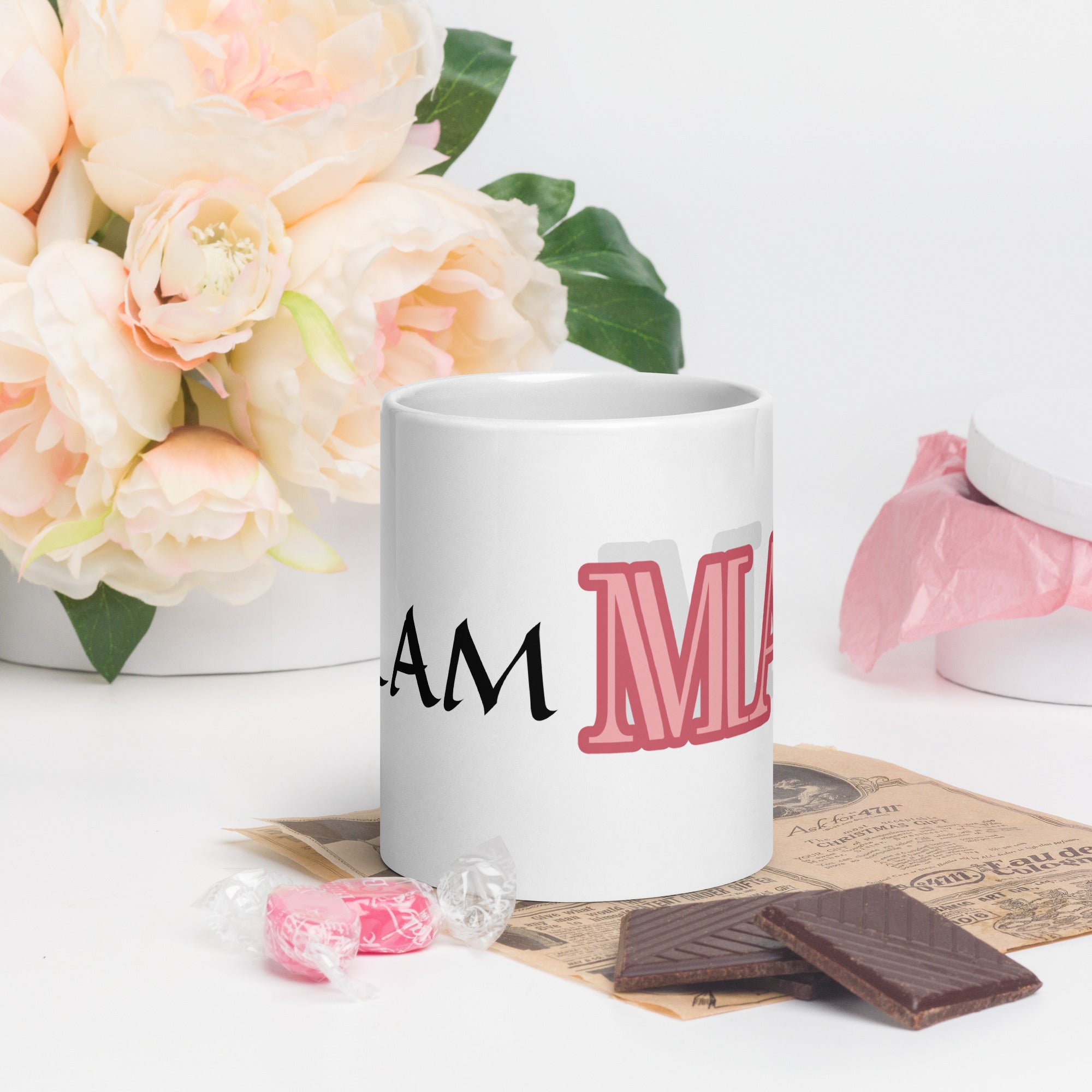 LuckeLadybug glam ma coffee mug with bold pink and black text next to flowers and chocolate pieces