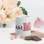 Glam ma coffee mug with stylish text design displayed on a white table with flowers and chocolates