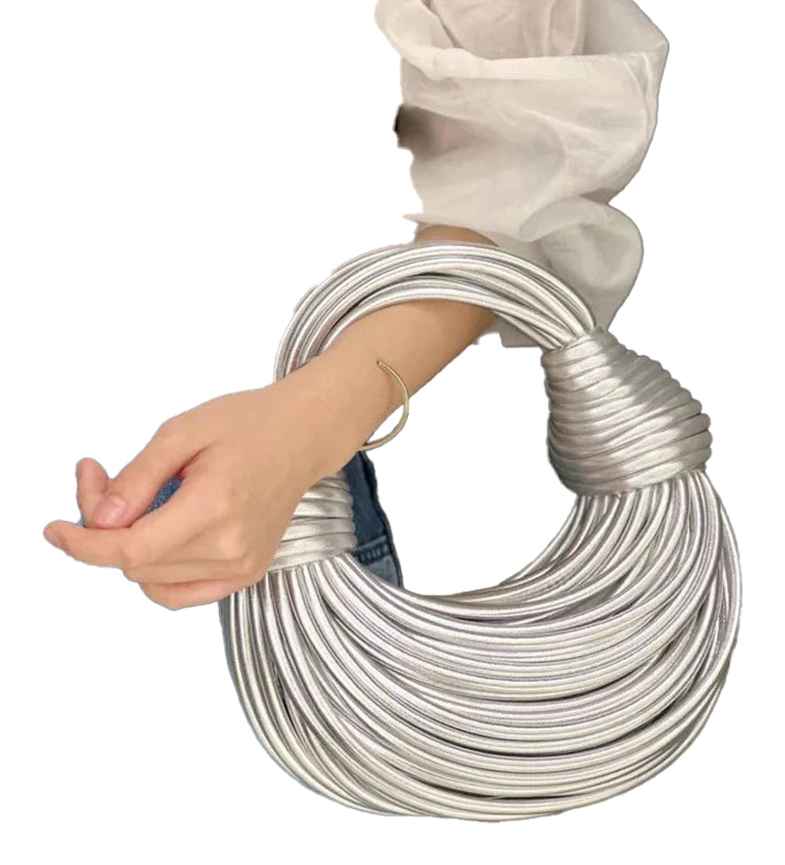 Stylish gold designer handwoven handbag with unique twist design held in hand