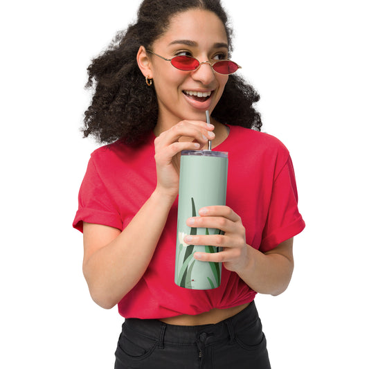 Woman holding green floral stainless steel tumbler with straw and lid while smiling
