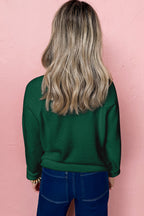 Back view of a green sweater worn by a model featuring a white MERRY Christmas sweater design