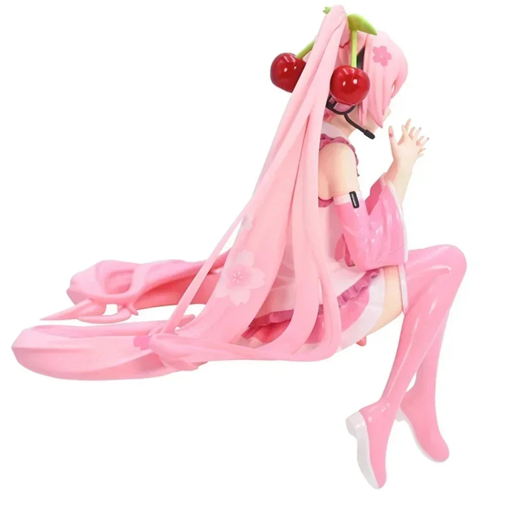 Hatsune Miku figurine sitting in a pink outfit with cherry accessories and long flowing hair