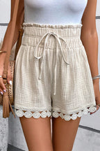 Beige high-waist shorts from LuckeLAdybug LLC with scalloped hem and drawstring waist detail