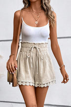 Women wearing stylish high-waist shorts with a tie waist and scalloped hem for a trendy summer look