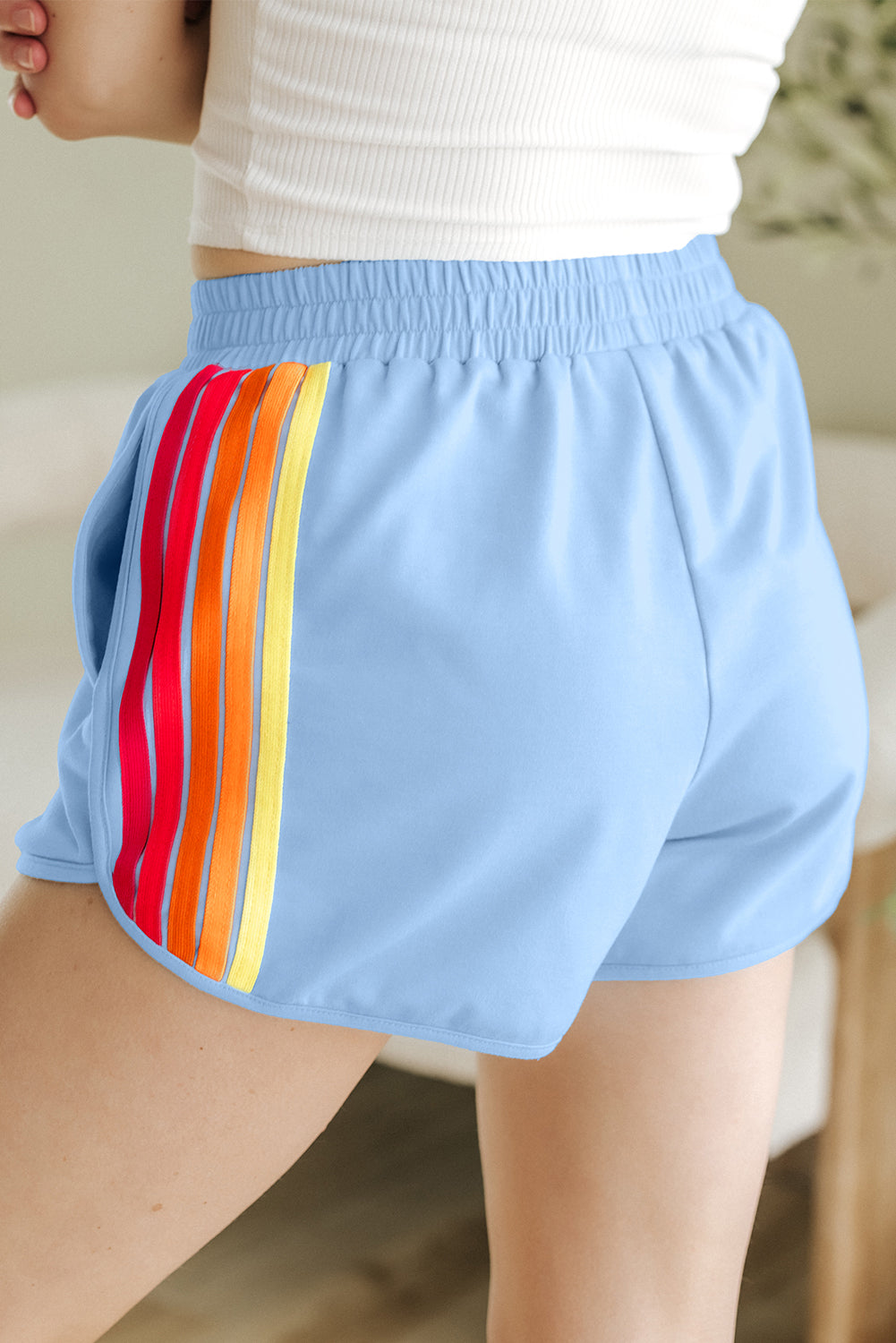 Blue high-waist shorts featuring vibrant striped accents in orange and yellow for a stylish look