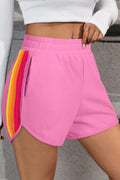 Pink high-waist shorts with colorful side stripes for a stylish summer look