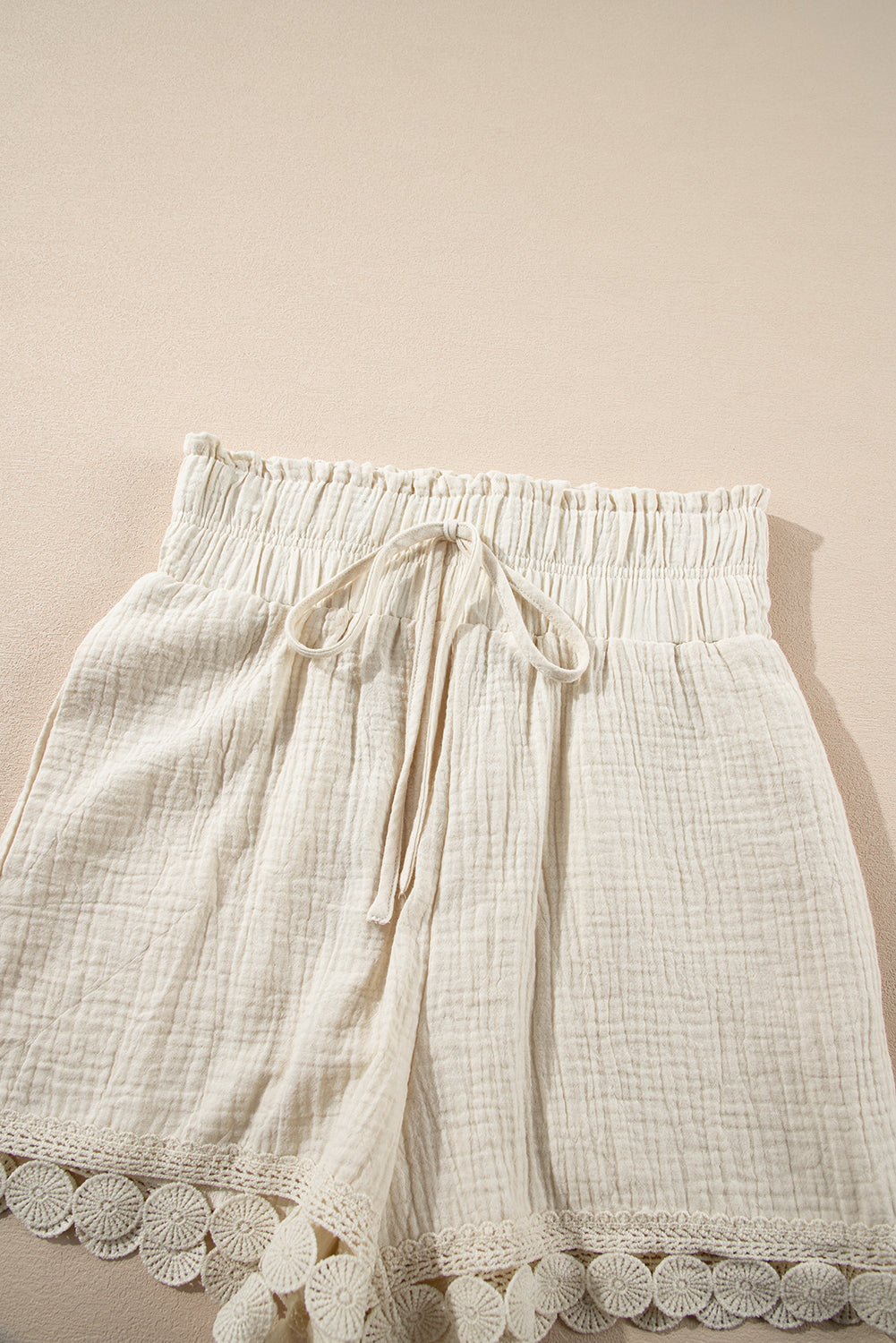 Lightweight cream high-waist shorts with a drawstring and lace trim for summer comfort
