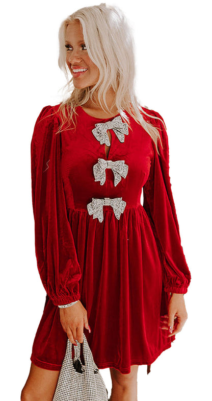 LuckeLadybug model wearing a fiery red velvet mini dress with long puff sleeves and rhinestone bows