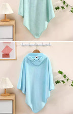 Soft mint green hooded newborn towel hanging on a wall, perfect for keeping baby warm after baths
