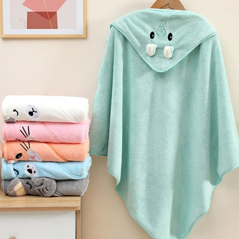 Soft LuckeLadybug LLC hooded newborn towel in mint green with animal ears, hanging beside colorful stacked towels