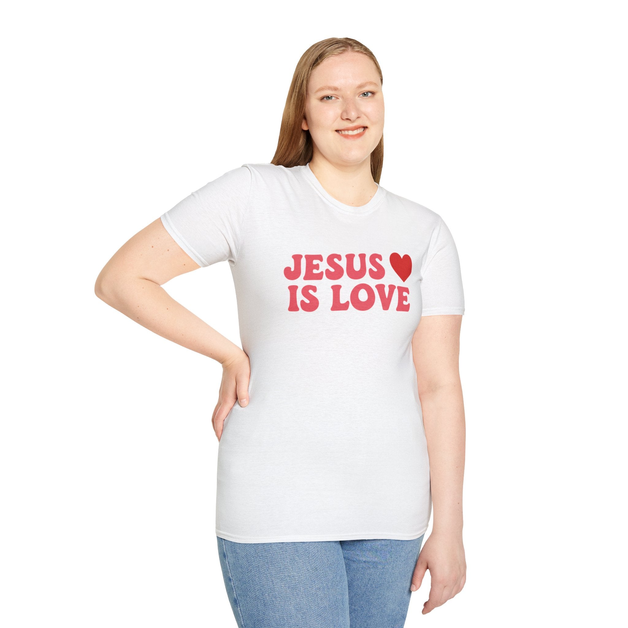 Woman wearing a white Printify Jesus is Love t-shirt with red text and heart design
