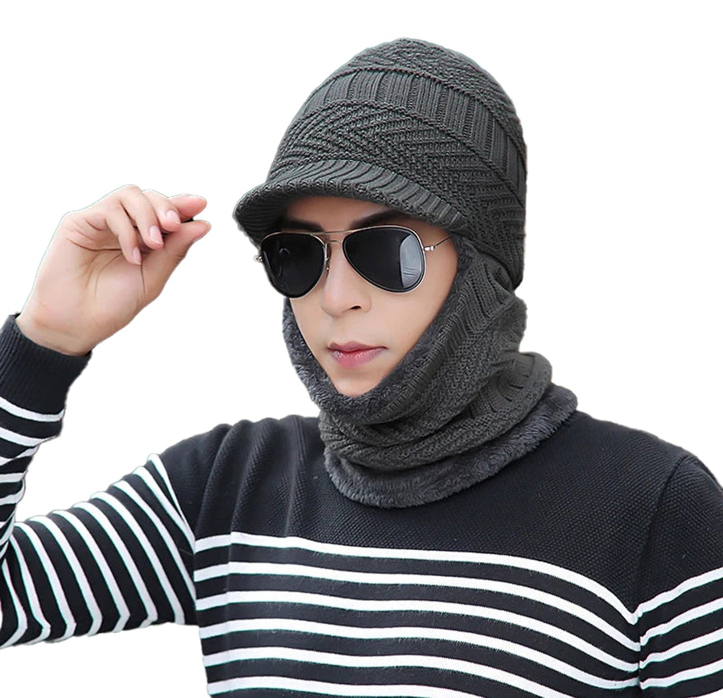 Stylish man wearing a knitted winter balaclava hat with sunglasses and a striped sweater
