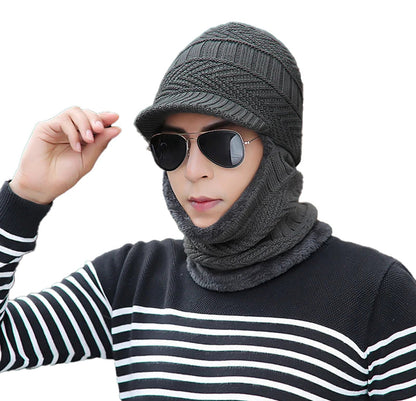 Stylish man wearing a knitted winter balaclava hat with sunglasses and a striped sweater