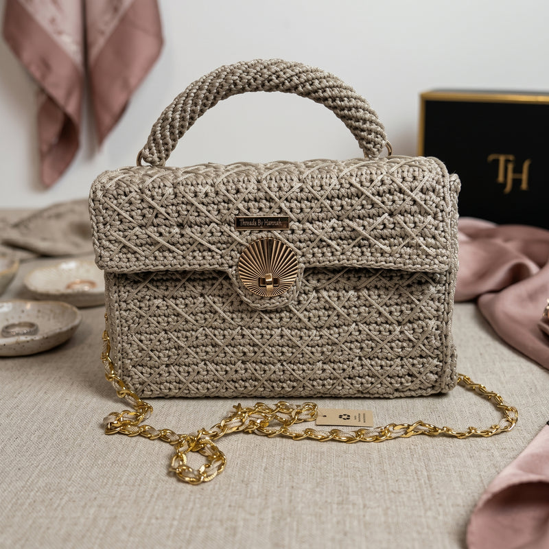 Stylish woven clutch with gold chain, featuring a clasp, perfect for any occasion as a leather crossbody mini bag