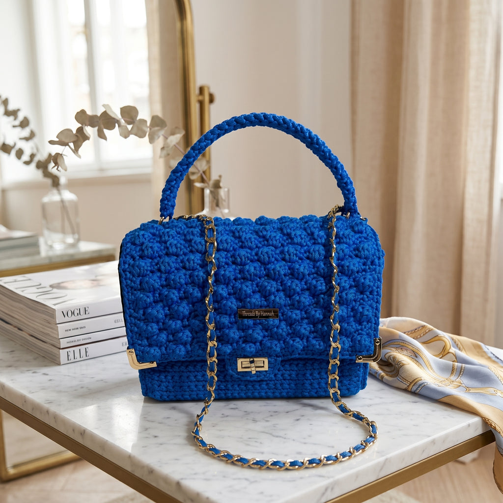 Bright blue leather handbag handmade with a structured design and stylish chain strap