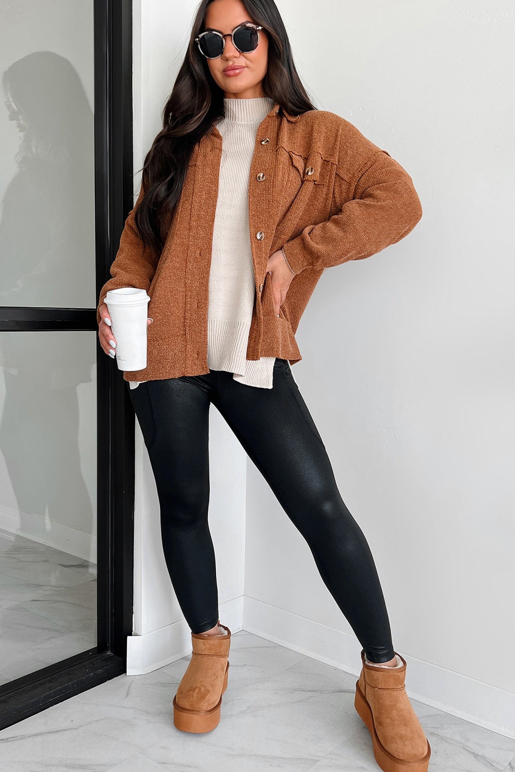 Fashionable high waist leggings in black worn with a cozy sweater and oversized jacket