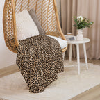 LuckeLadybug leopard print sherpa blanket draped over hanging wicker chair in cozy room