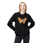 Black let them butterfly sweater with orange butterfly graphic worn by woman posing with hands on hips