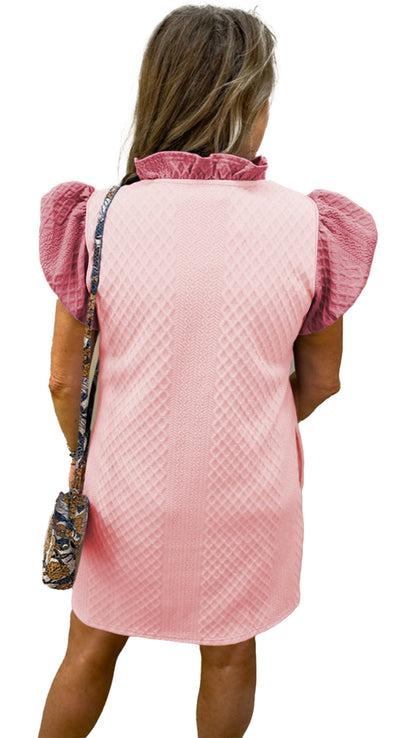 Back view of a light pink puff sleeve mini dress with ruffled neckline and patterned sleeves