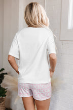 Woman in white top and pink shorts embodies comfort in a stylish lounge room set