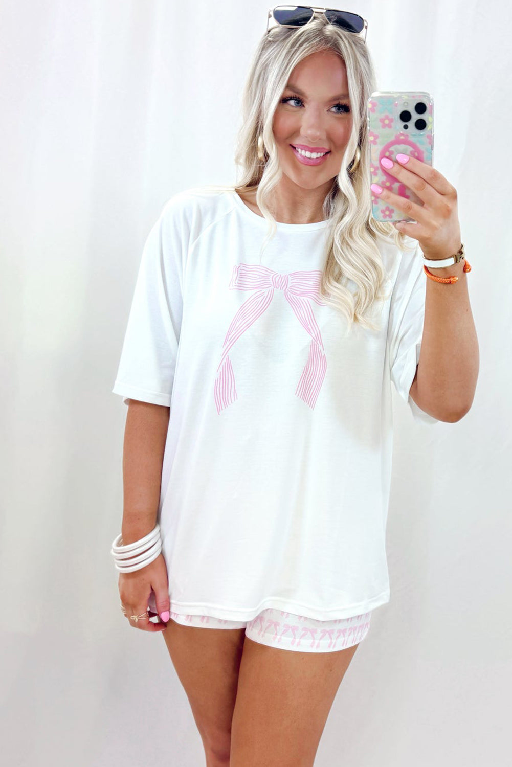Comfortable white top with pink bow design and matching shorts for lounging, perfect for a lounge room set