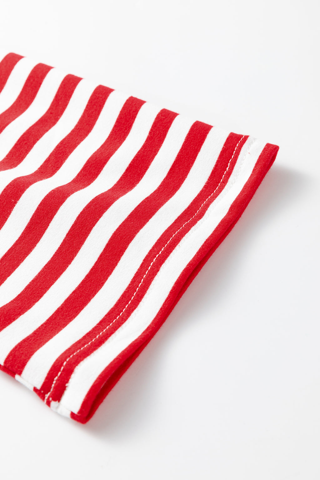 Red and white striped fabric close-up for a stylish loungewear set by LuckeLadybug LLC