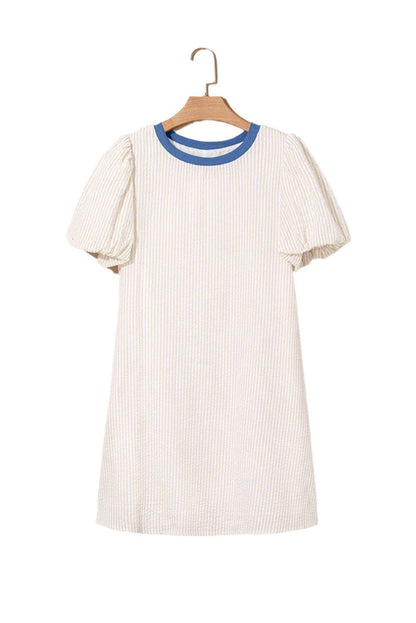Beige stripe seersucker dress with blue collar and puff sleeves hanging on wooden hanger