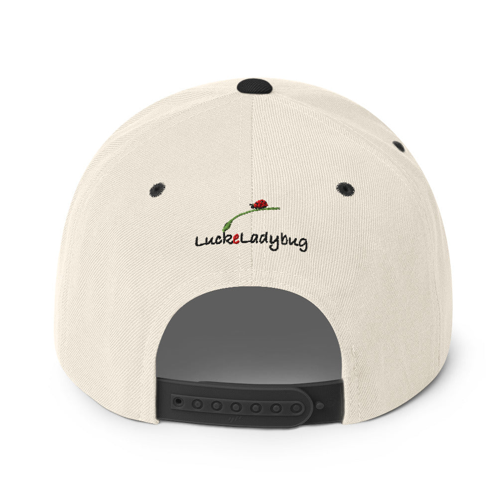 Back view of LuckeLadybug beige dragonfly snapback hat with adjustable black strap and embroidered logo