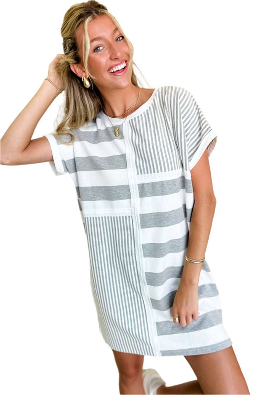 Woman wearing a gray stripe t shirt dress with mixed horizontal and vertical stripes by LuckeLadybug LLC