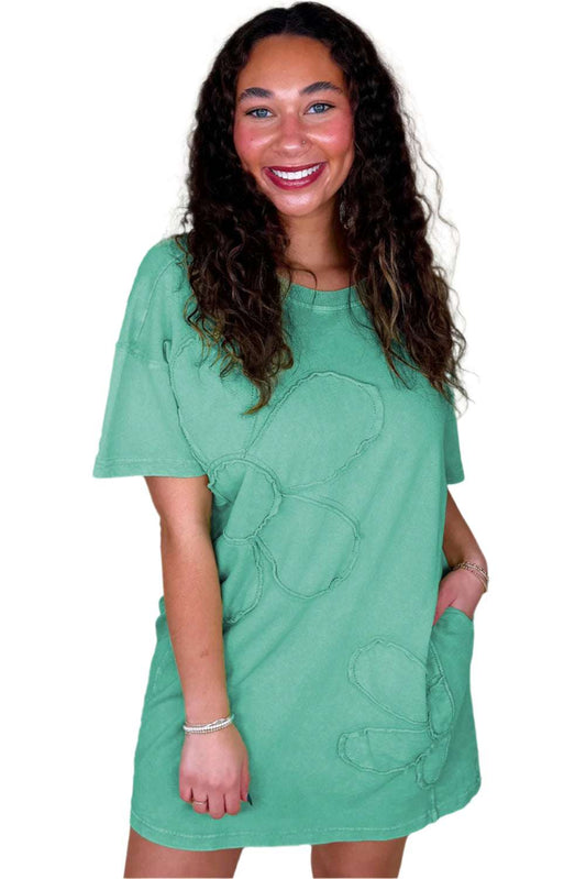 Woman wearing a mint green t shirt dress with floral stitch details and short sleeves