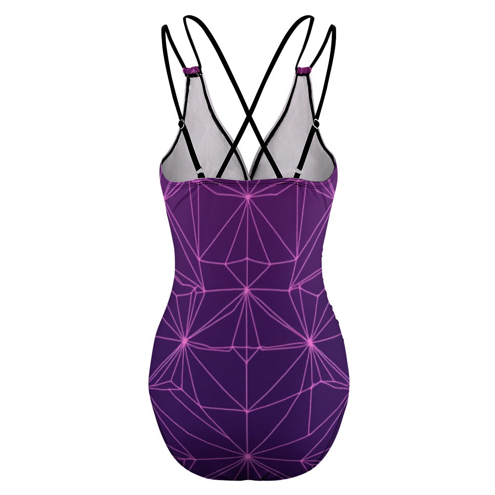Back view of purple abstract one-piece swimsuit with geometric pattern and black crisscross straps