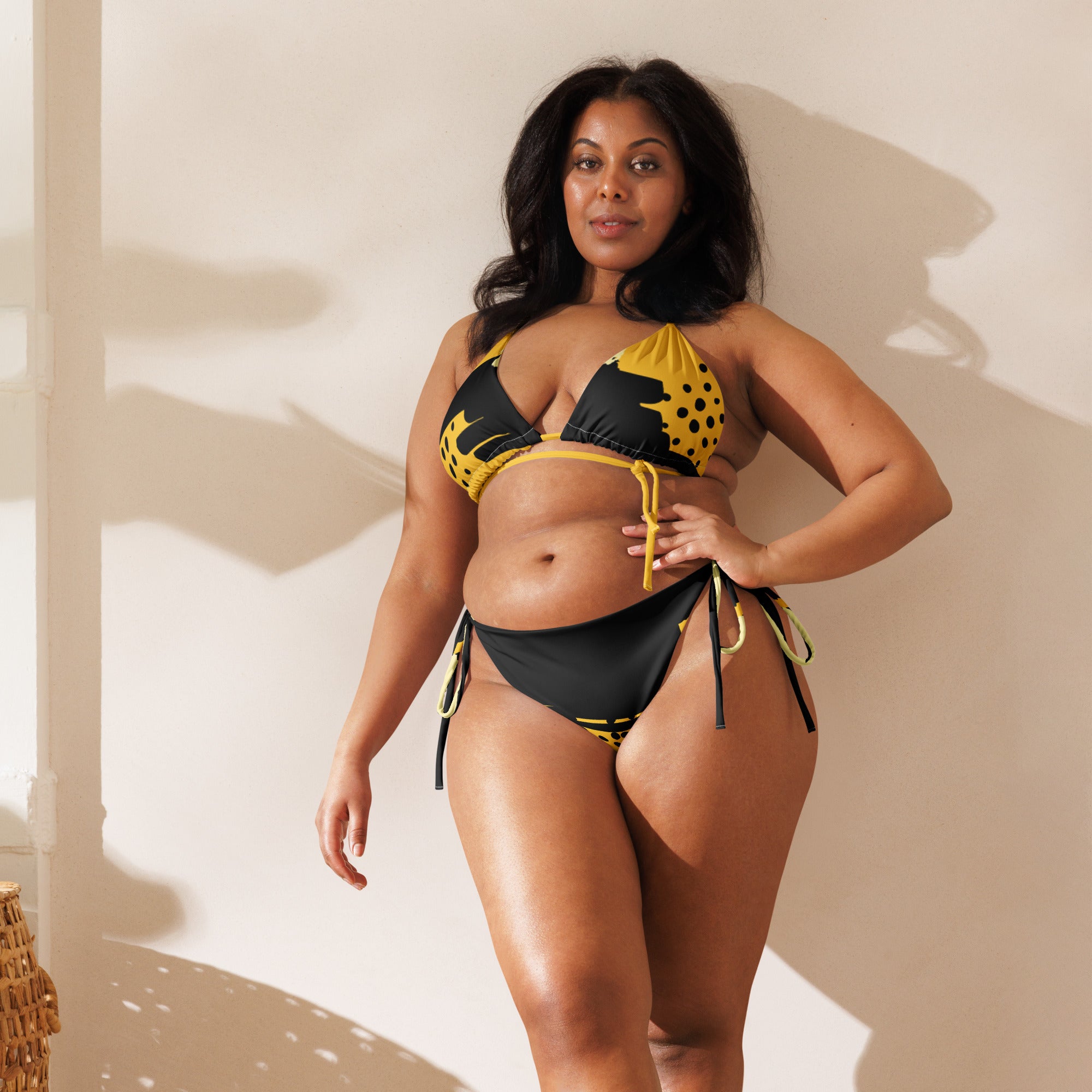 yellow black abstract bikini worn by a confident plus size woman posing indoors