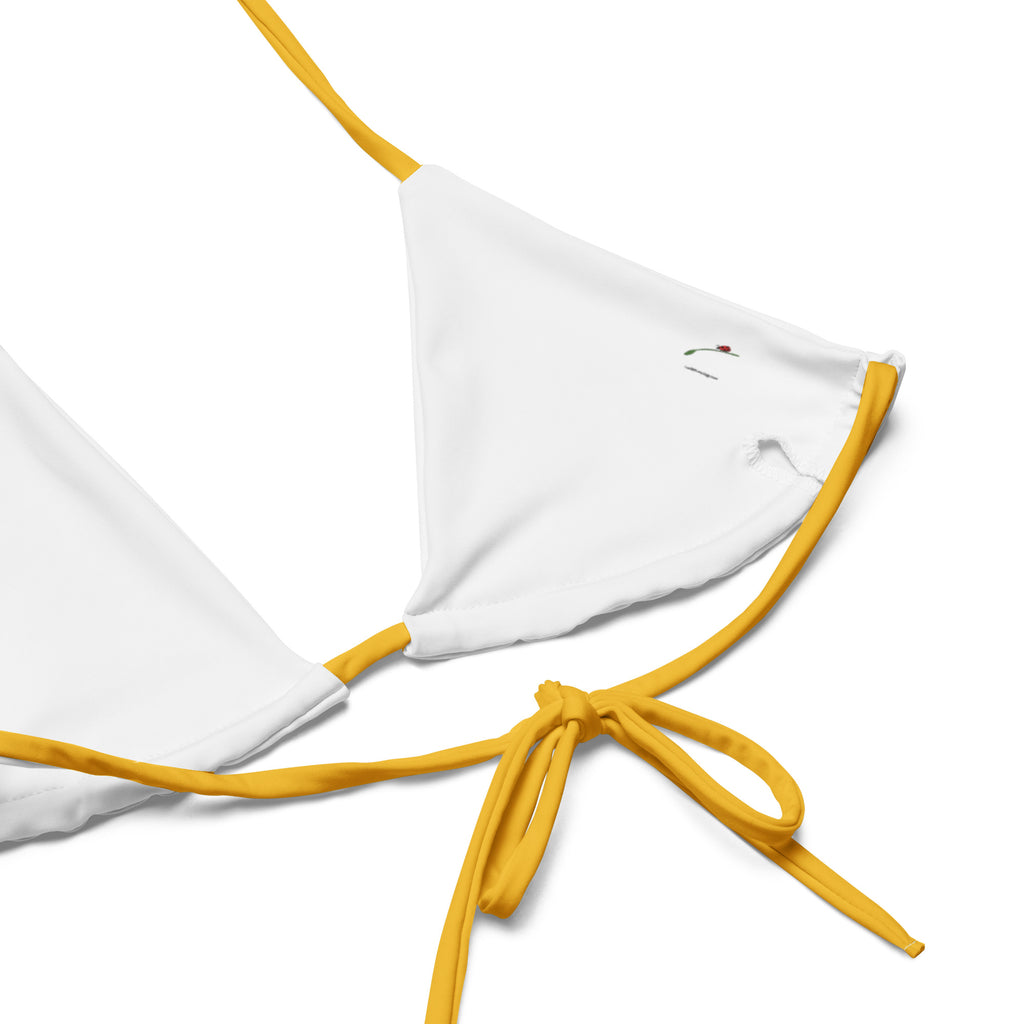 Close-up of a yellow black abstract bikini top with yellow straps on white background