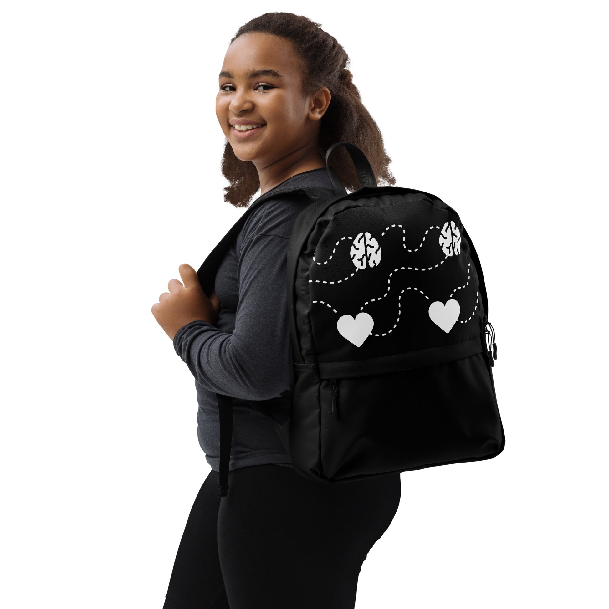 LuckeLadybug Black Backpack With White Hearts worn by smiling girl school backpack with zip pocket and adjustable straps