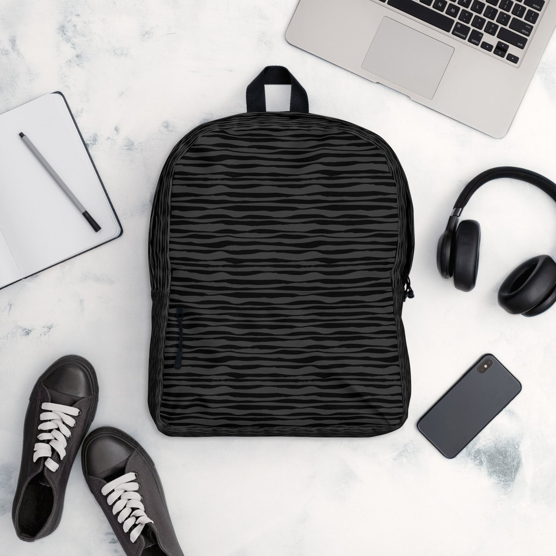 LuckeLadybug black striped backpack shown with laptop headphones phone and sneakers for daily commute