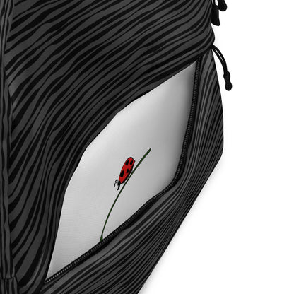 LuckeLadybug black striped backpack with front zip pocket open showing white interior and ladybug print