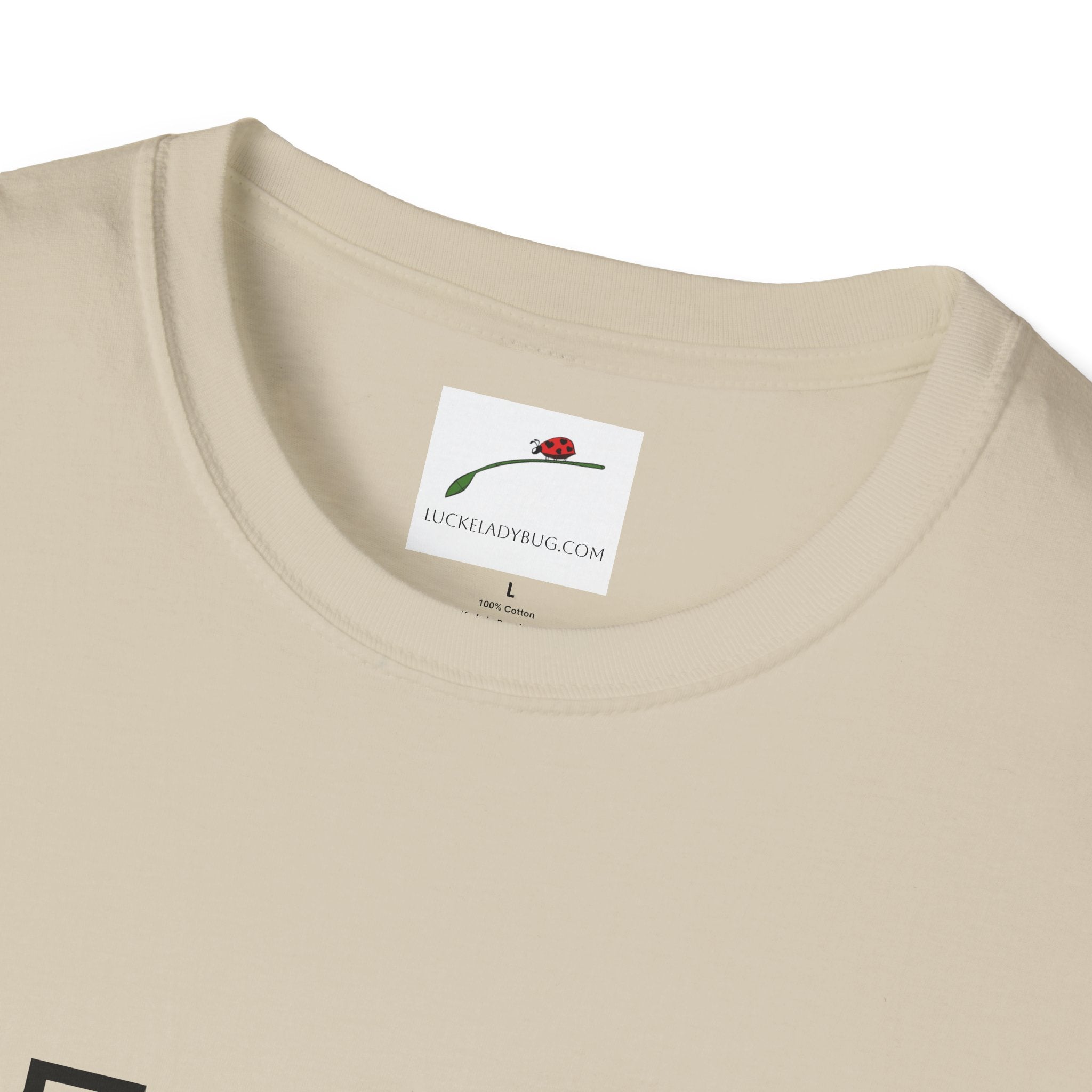 Close-up of LuckeLadybug beige cotton fifty something t shirt collar and label