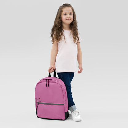 Pink backpack for teens and adults held by young girl wearing white shirt and jeans