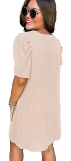 Back view of model wearing parchment knit mini dress ribbed short puff sleeves casual summer outfit